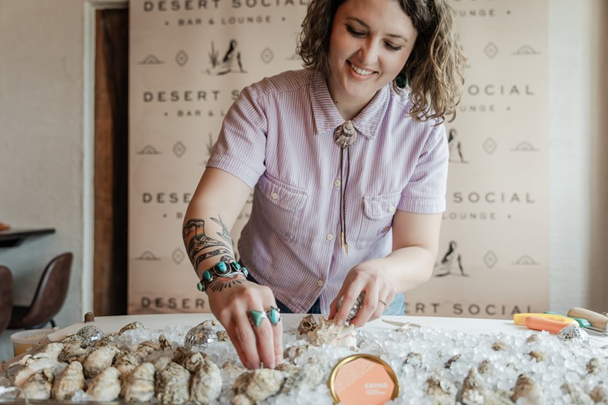 woman standing behind a tray of oysters