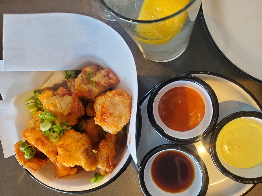 small pieces of fried chick next to several sauces