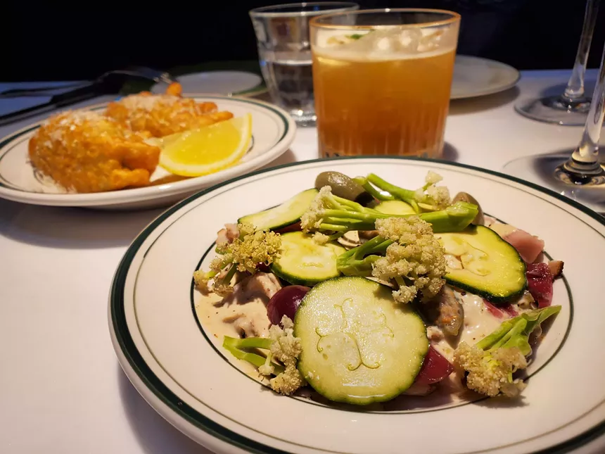 a dish topped with sliced cucumber and cauliflower florets