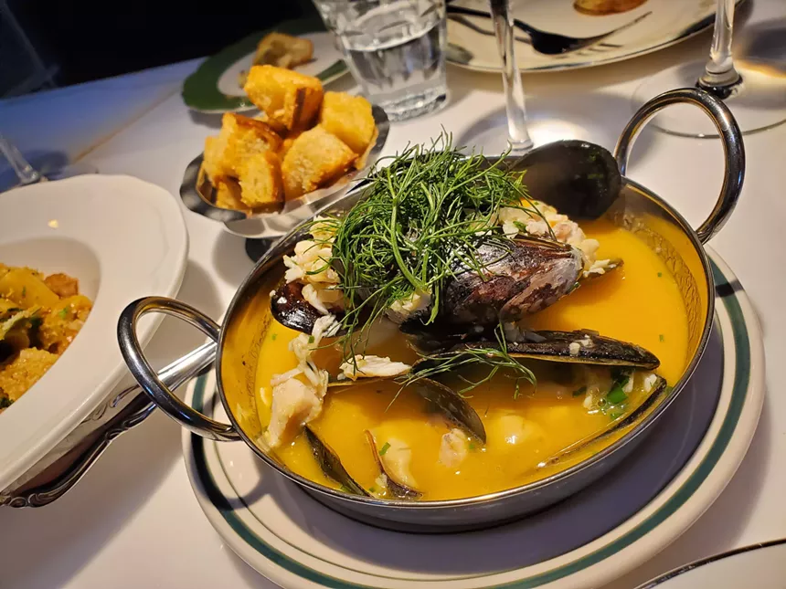 a bowl of mussels in a yellow broth