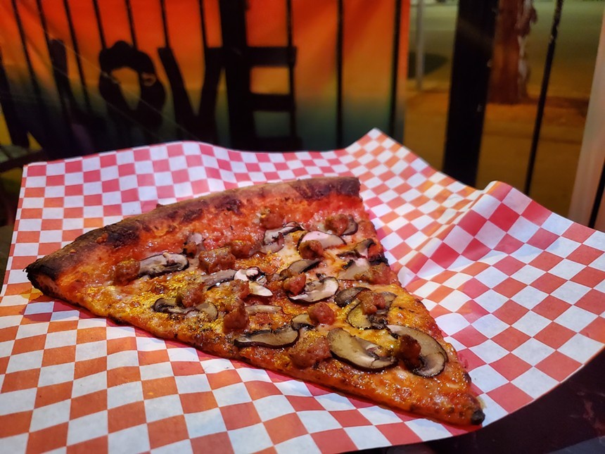 a slice of mushroom and sausage pizza
