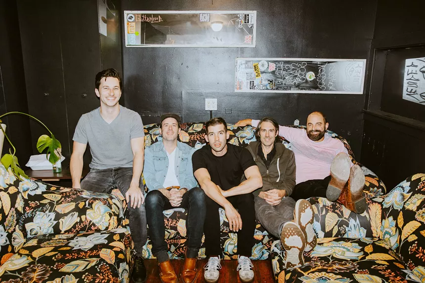 bandmates sitting on a floral couch