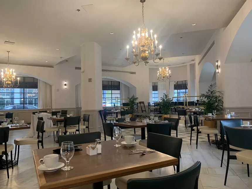 marble dining room with chandeliers.