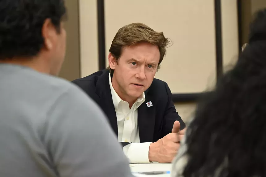 Mayor Mike Johnston listens to a resident.