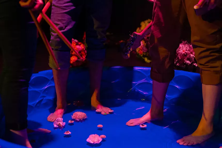 view of people's feet in a kiddie pool