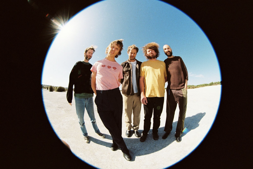 five men pose in front of a fish-eye lens
