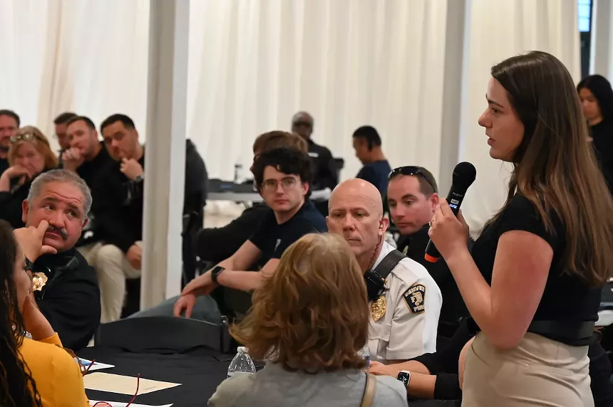 A woman speaks at a town hall.
