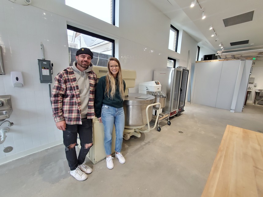 man and a woman posting in a room with baking equipment.