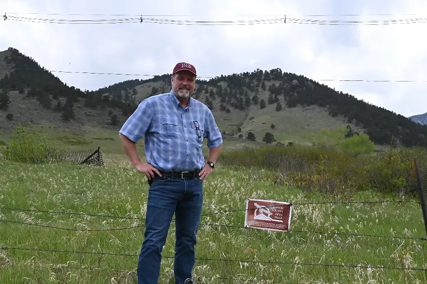 A man stands in front of the hills.