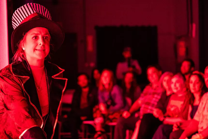 woman in a top hat and jacket in front of an audience