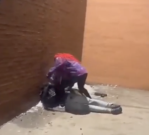 Two people on the ground during a fight.