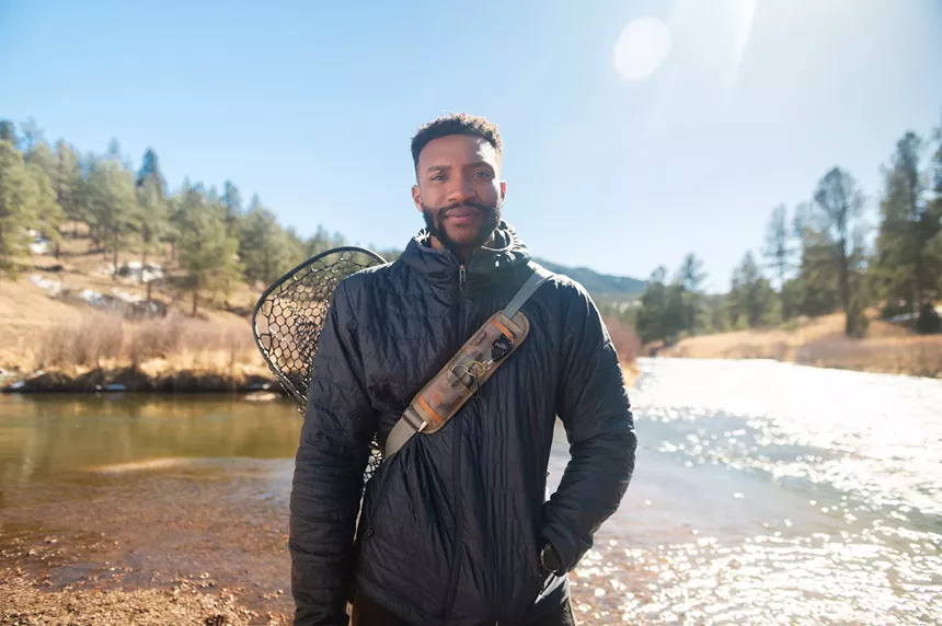 Austin Campbell, a Black fly fishing guide with Wanderland Outdoors, posed along a river