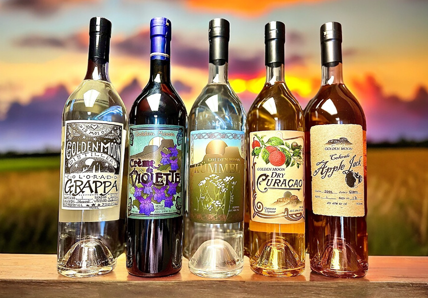 various bottles of liquor in front of a sunset