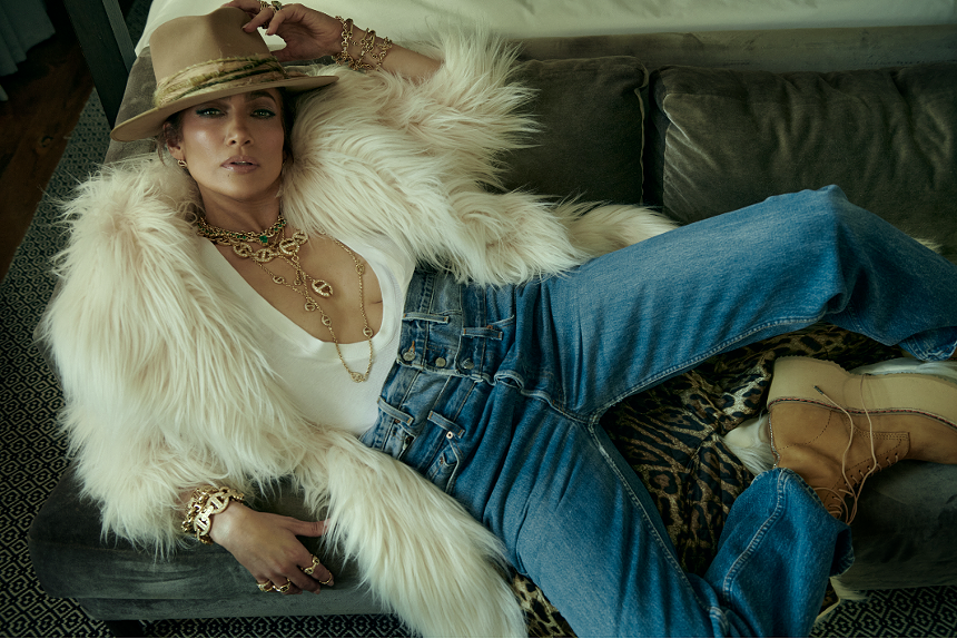 jennifer lopez lying down in a white coat and jeans