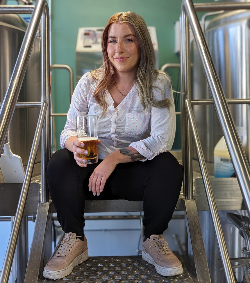 A woman sits on the deck of a brewery.