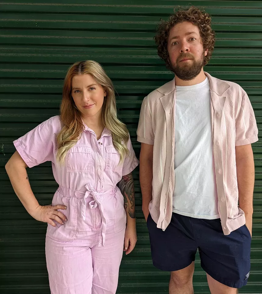 A man and a woman in front of a garage.