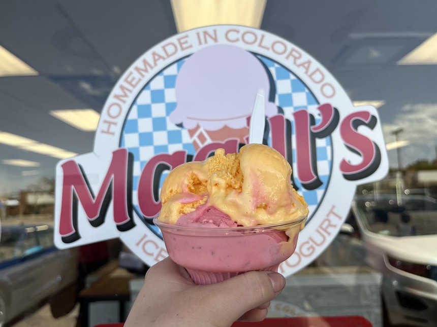 hand holding a cup of pink and orange ice cream