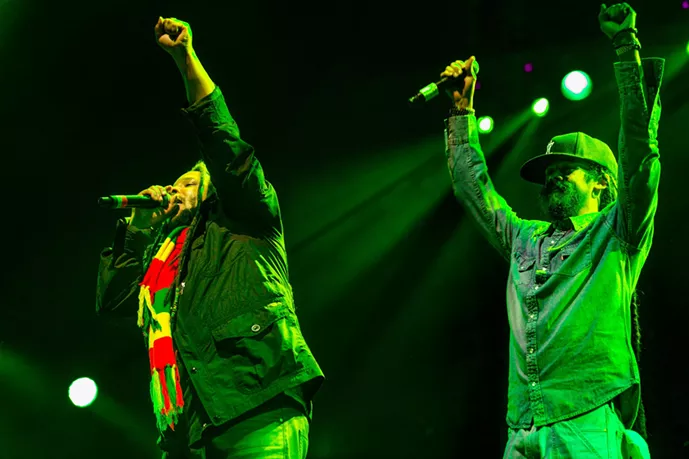 Two men on stage with arms raised