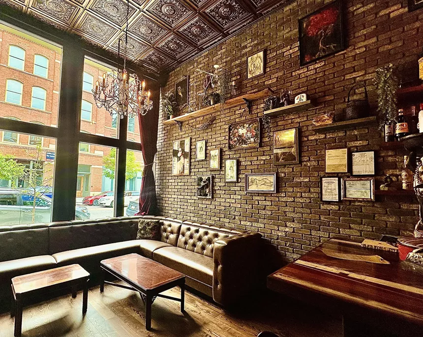 a room with a brick wall and a leather couch