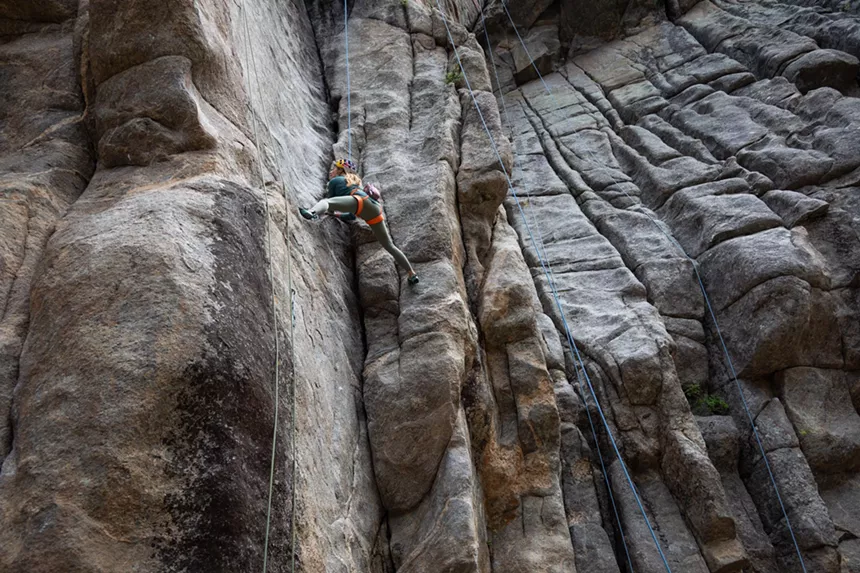 Woman climbs sandsotne wall