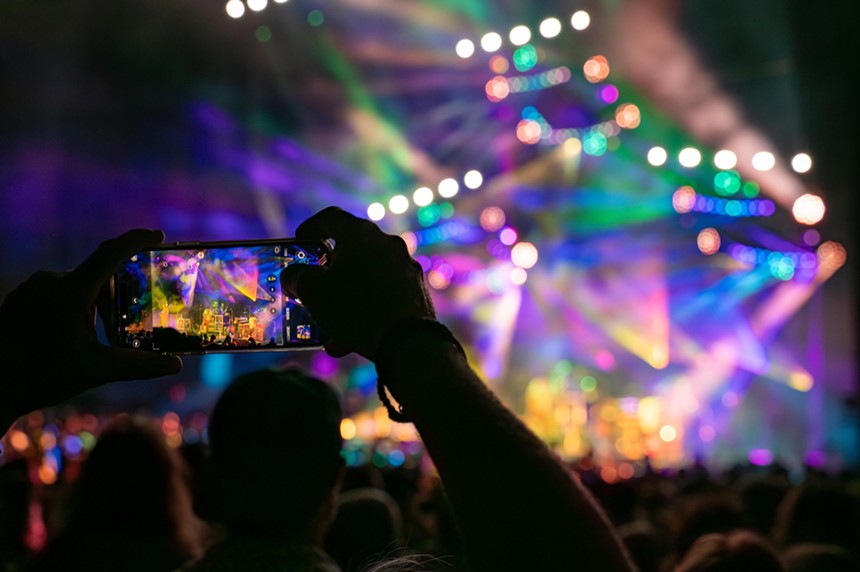 person holding phone to video concert
