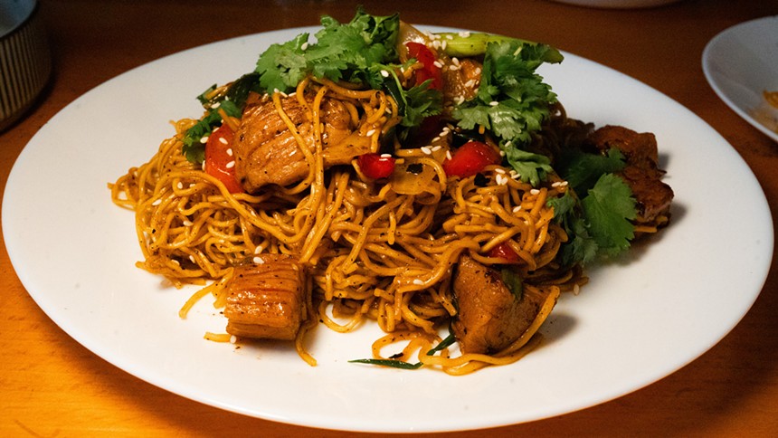 noodle and beer stir fry on a white plate