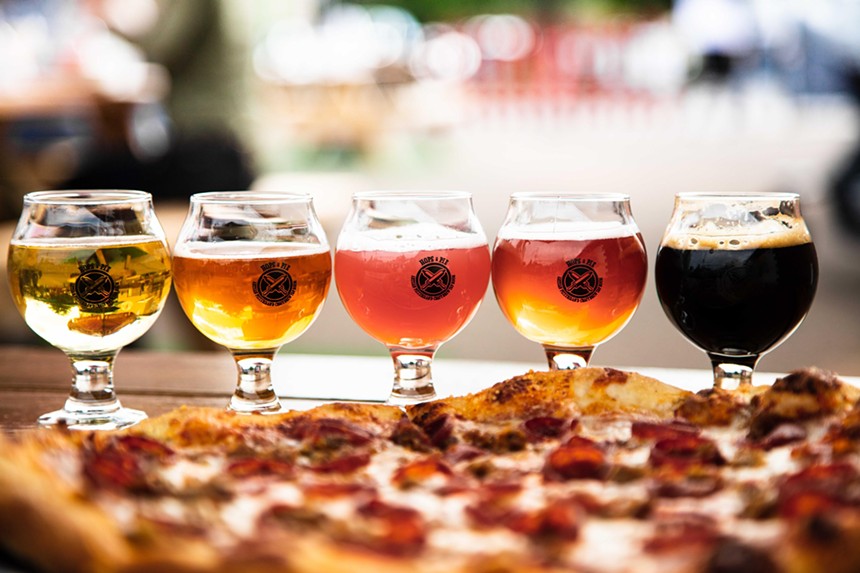 Photo of various colored beers and pizza.