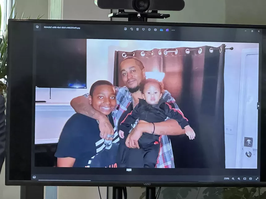 Aurora police shooting victim Kilyn Lewis holding his sons in a photo.