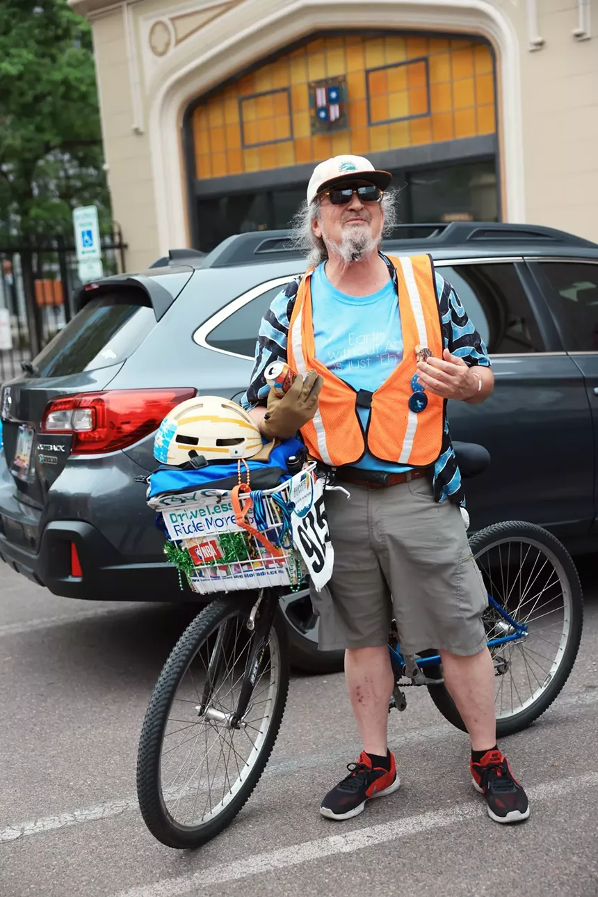 man in crossing jacket next to his bike