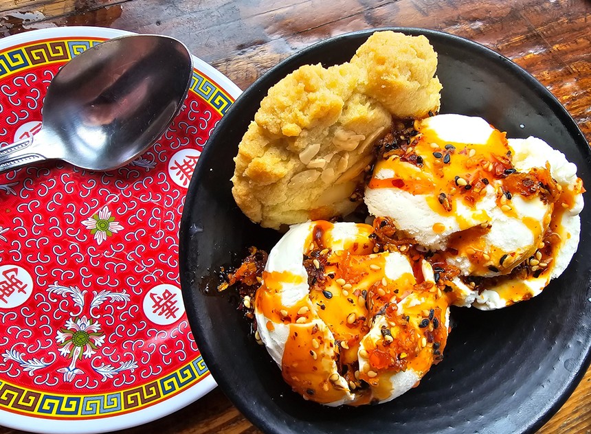 scoops of vanilla ice cream topped with chili crispy in a bowl with a shortbread cookie