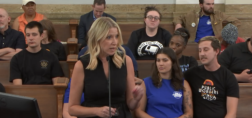 Woman speaks at microphone during city council hearing