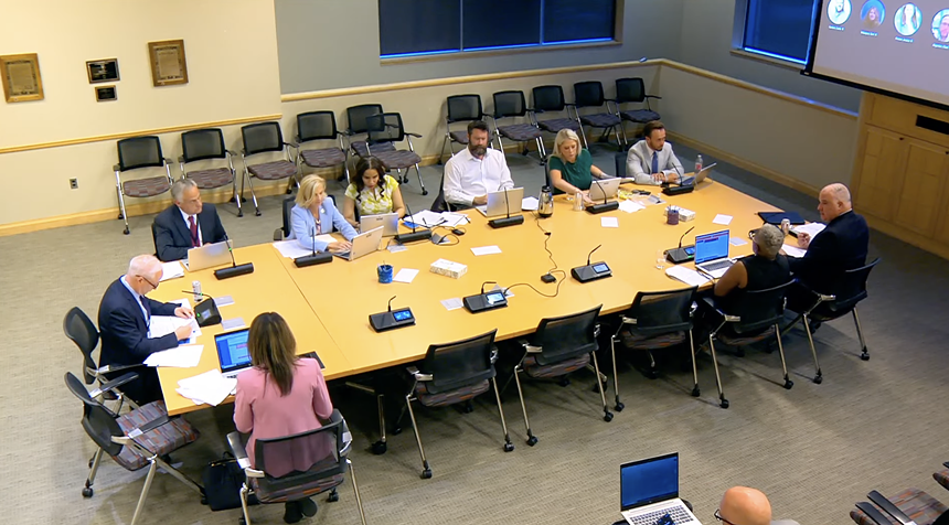 Aurora City Council members meeting and discussing things at a table behind closed doors.