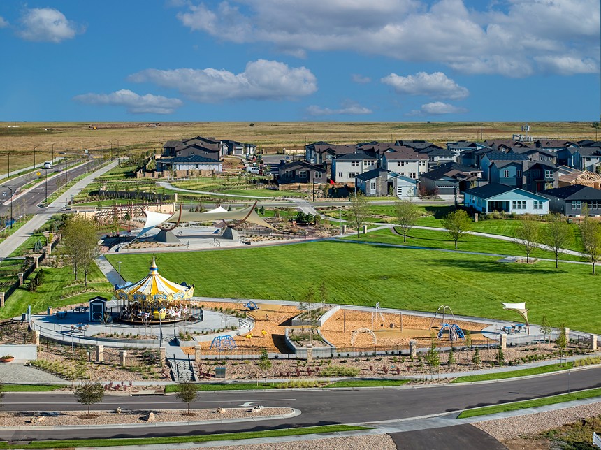 An aerial view of Winged Melody Park featuring a carousel, large grassy lawn and amphitheatre