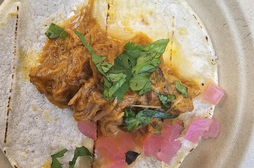 a taco with cilantro and pickled onions