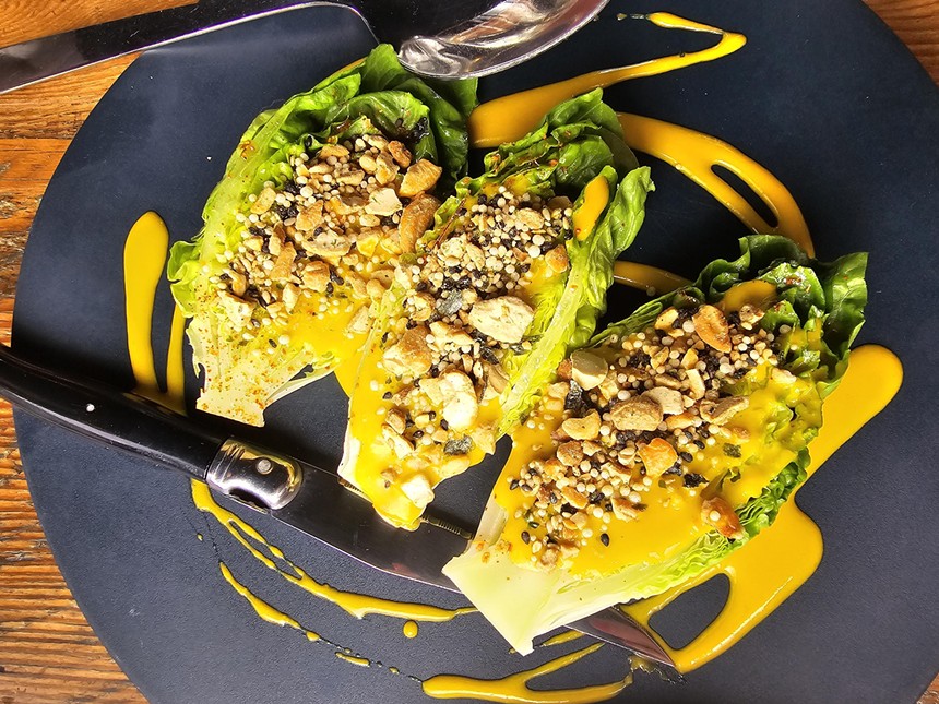 wedges of little gem lettuce covered in a bright yellow dressing