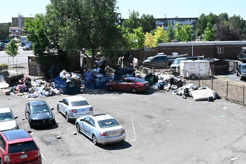 Trash piles up outside an apartment.