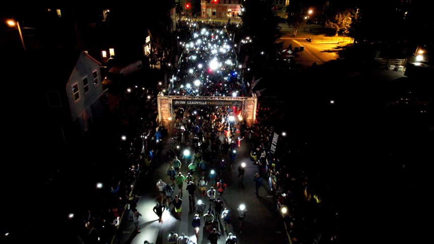 An aerial view of the Leadville Trail 100 ultramarathon starting in the dark, with runners wearing headlamps