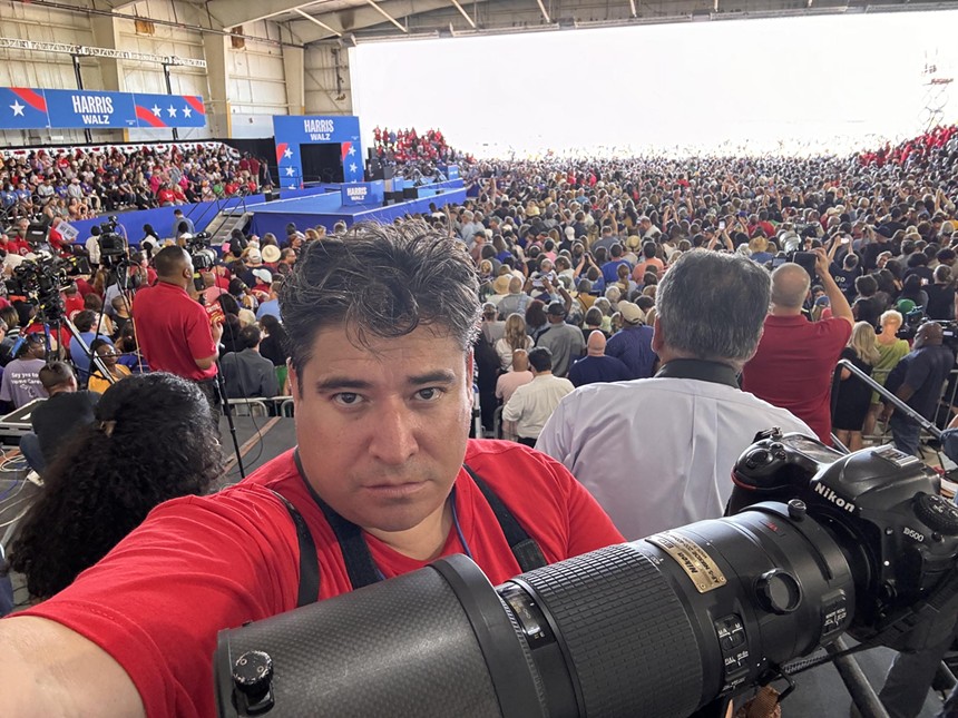 man with camera with big crowd, plane behind