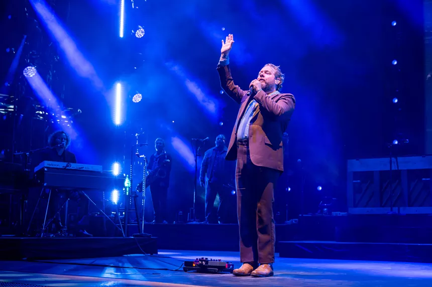 Man singing with his hand in the air.