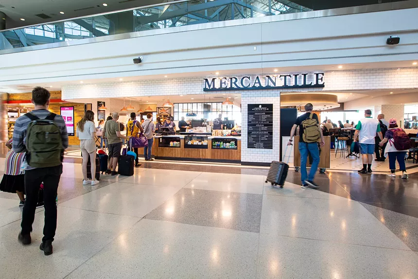people standing in line at a restaurant counter at an airport