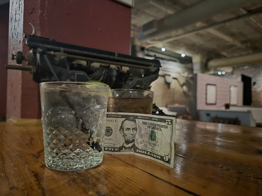 a five-dollar bill next to two drinks