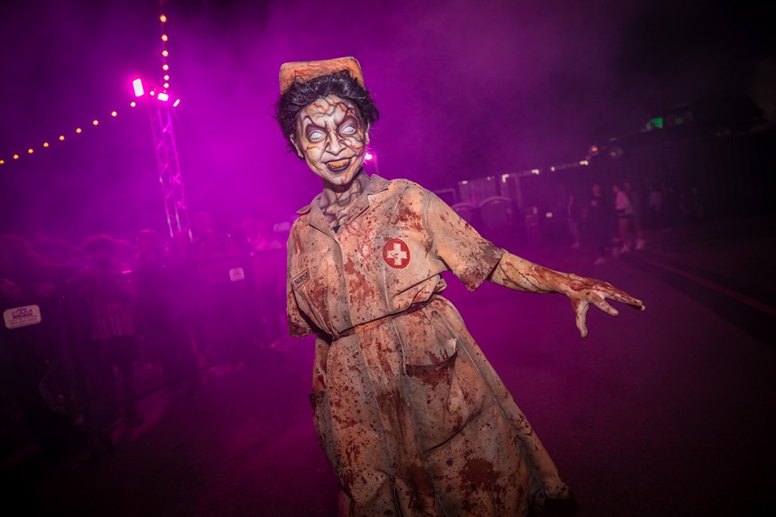 A 13th Floor Haunted House actor dressed in a blood-stained nurse costume