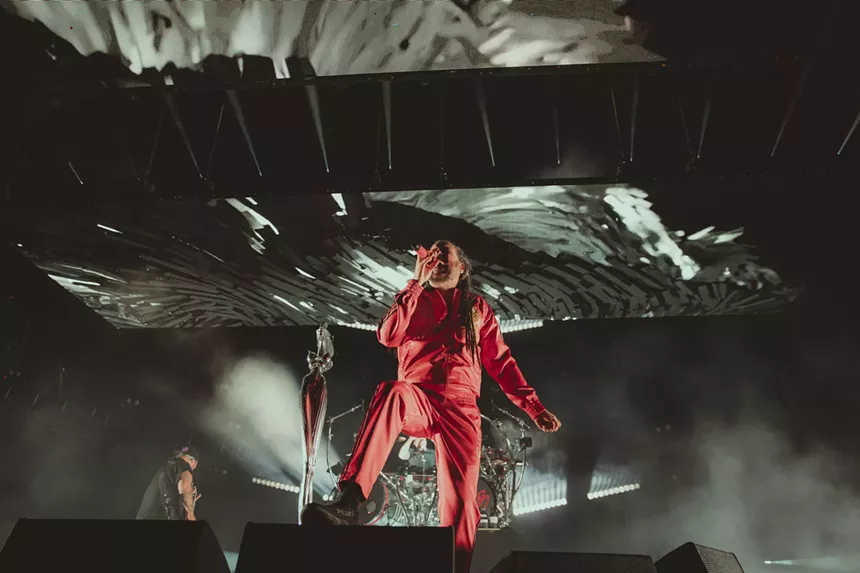 a man in a red jumpsuit holding a microphone