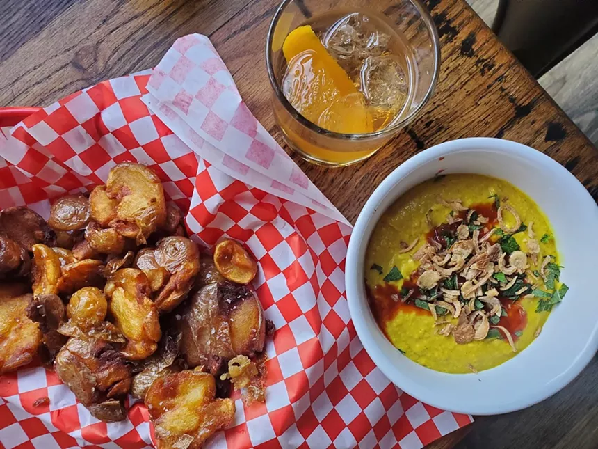 basked of fried potatoes next to a bowl of dip