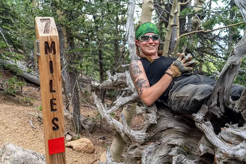 Mandy Horvath leaning on a tree stump along the Barr Trail