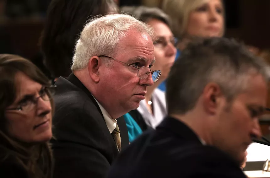 man with white hair testifying