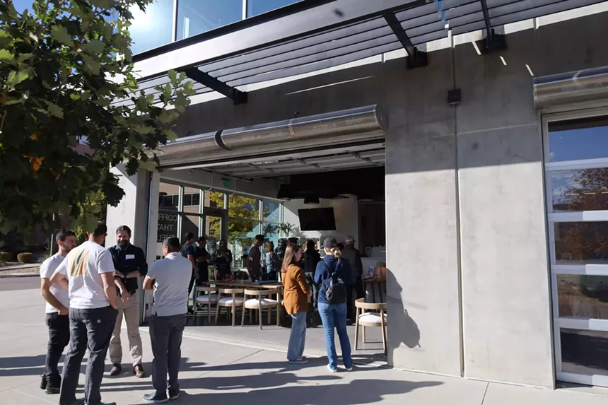 people standing outside a coffee shop
