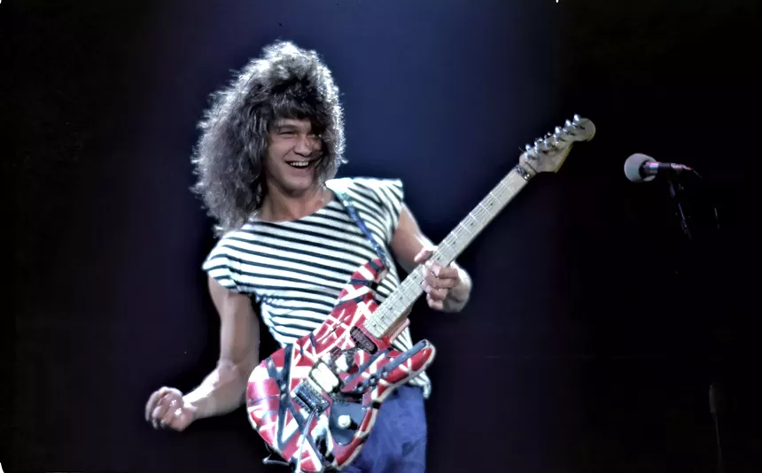 eddie van halen playing guitar and smiling