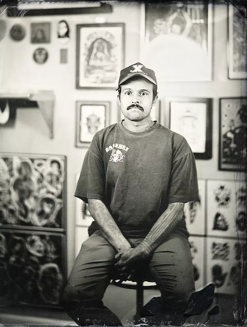 Santiago Padilla-Jaramillo sitting in his station in Skull and Dagger Tattoo Co.