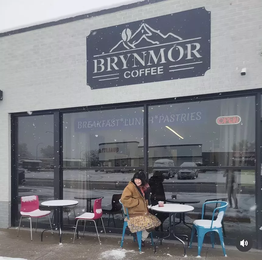 person sitting at a table outside a cafe